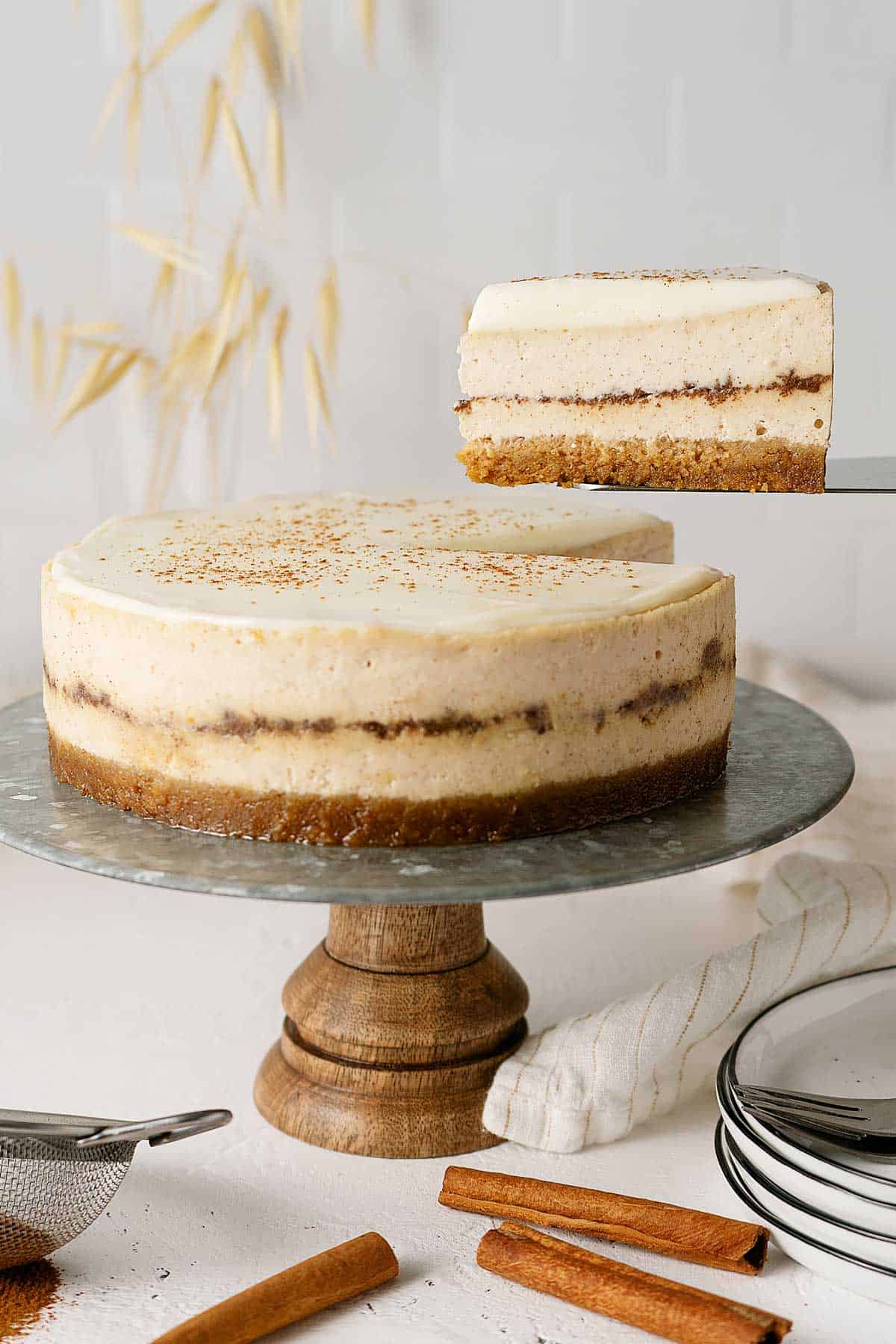 cinnamon roll cheesecake on a stand.