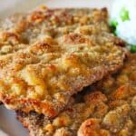 Oven baked steak milanesa served with rice and peas