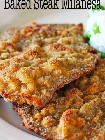 Oven baked steak milanesa served with rice and peas