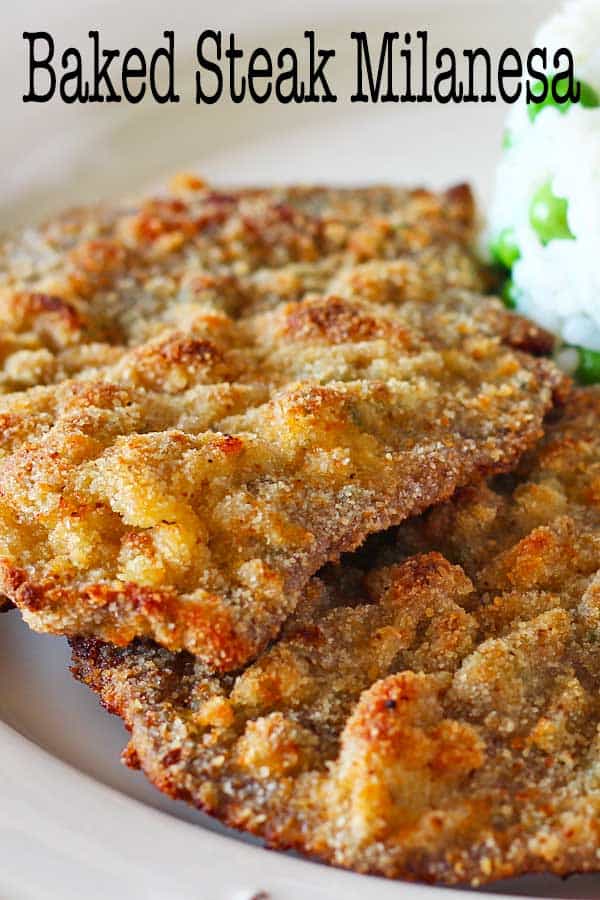 Oven baked steak milanesa served with rice and peas