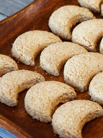 Halfmoon coconut cookies served on a wooden tray