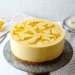 no-bake mango cheesecake on a cake stand