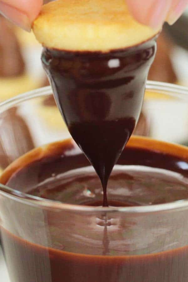 dipping the dulce de leche cone in chocolate