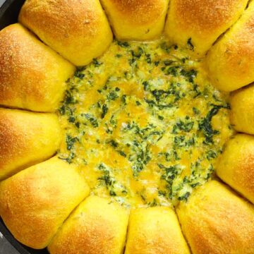 curry bread with cheese spinach dip in a cast iron skillet