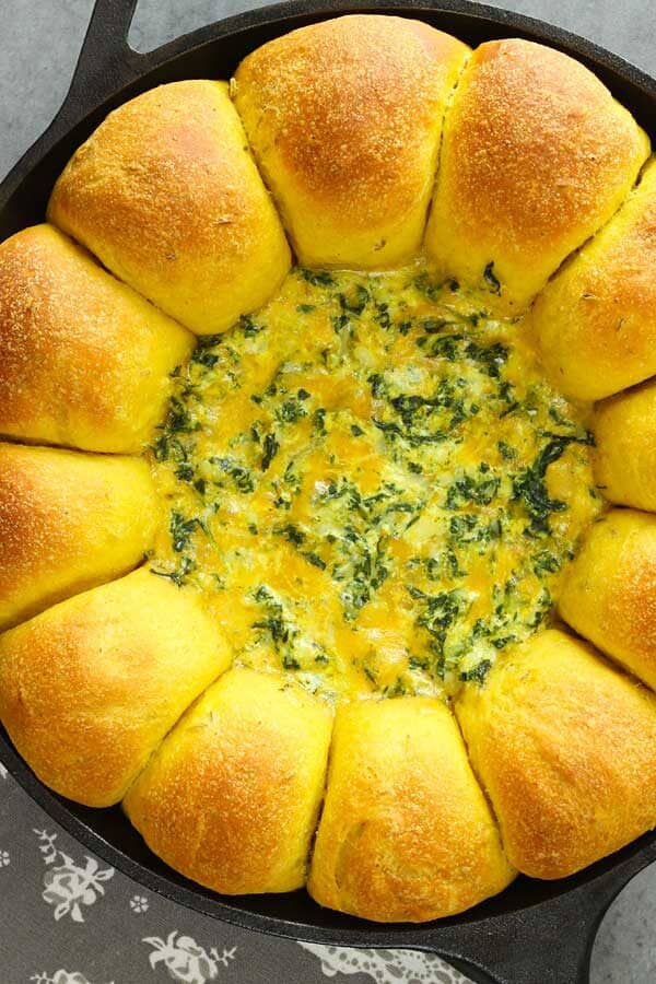 curry bread with cheese spinach dip in a cast iron skillet