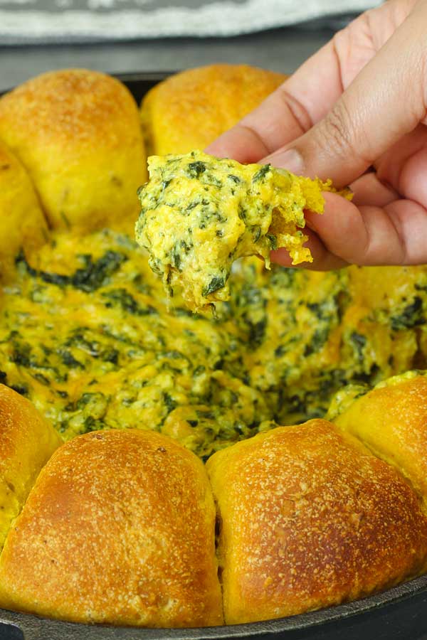 eating curry bread dipped in cheese spinach dip