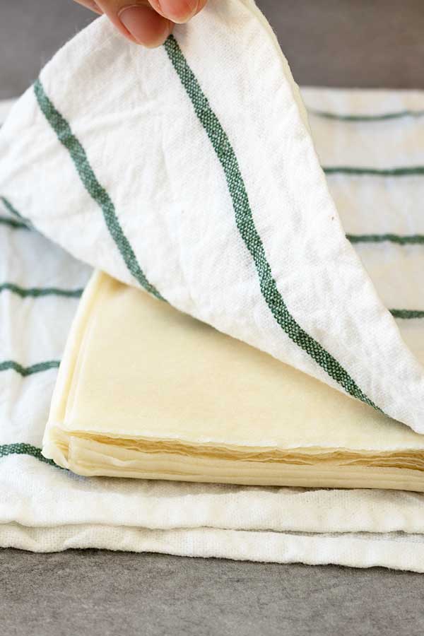 Spring roll sheets covered with a damp kitchen towel