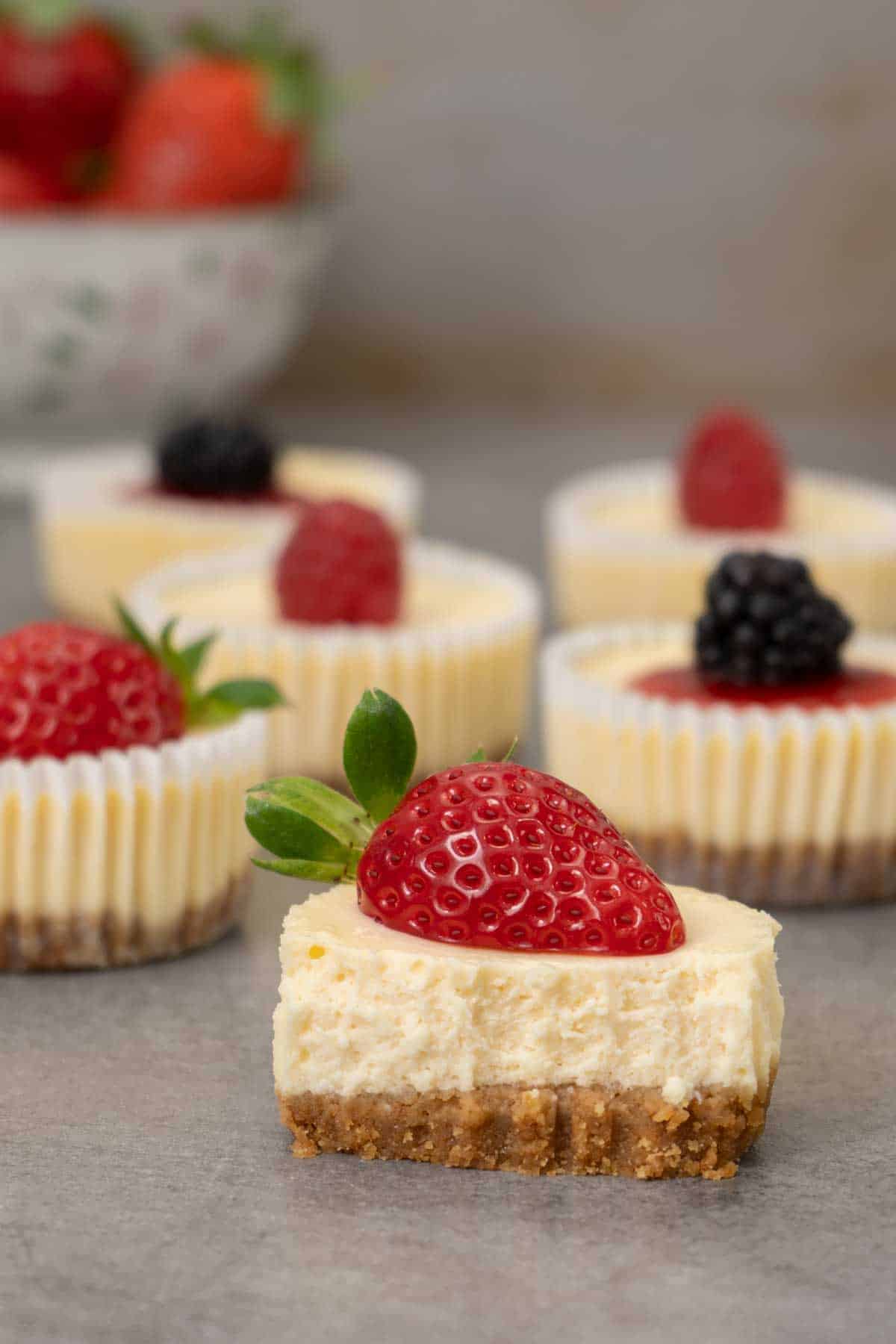 A half eaten mini cheesecake on a table