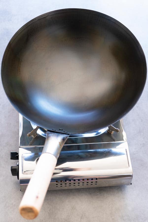 a carbon steel wok just seasoned over a stove