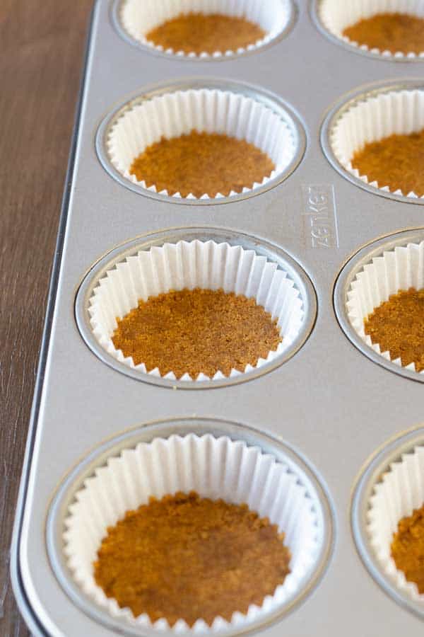 Mini cheesecakes biscuit base in a muffin pan