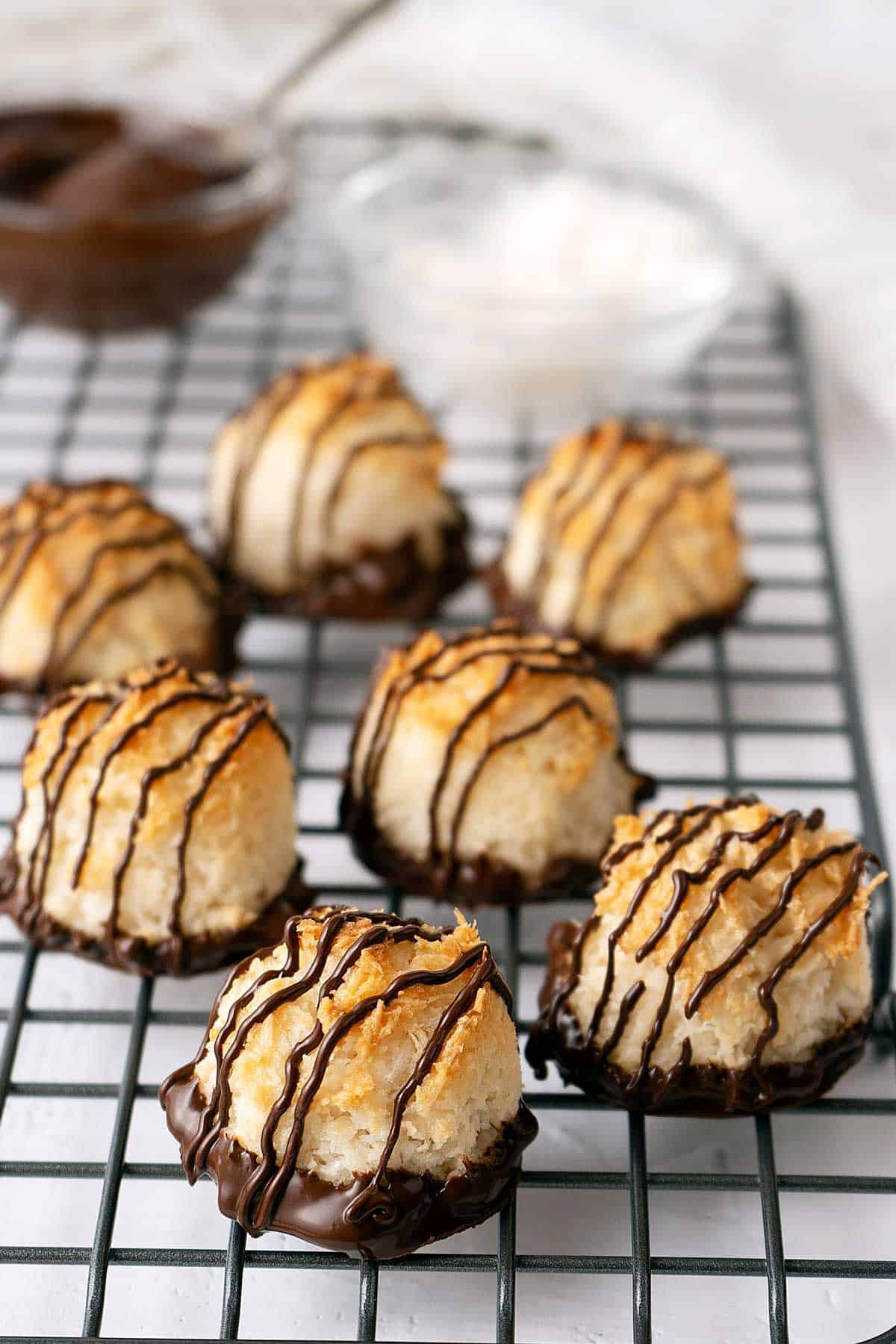 coconut macaroons with chocolate on a cooling rack