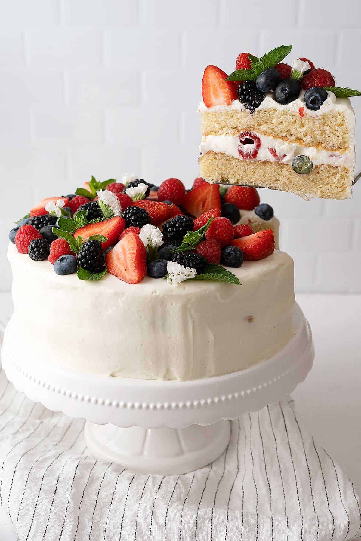 Serving a berry cake with white frosting