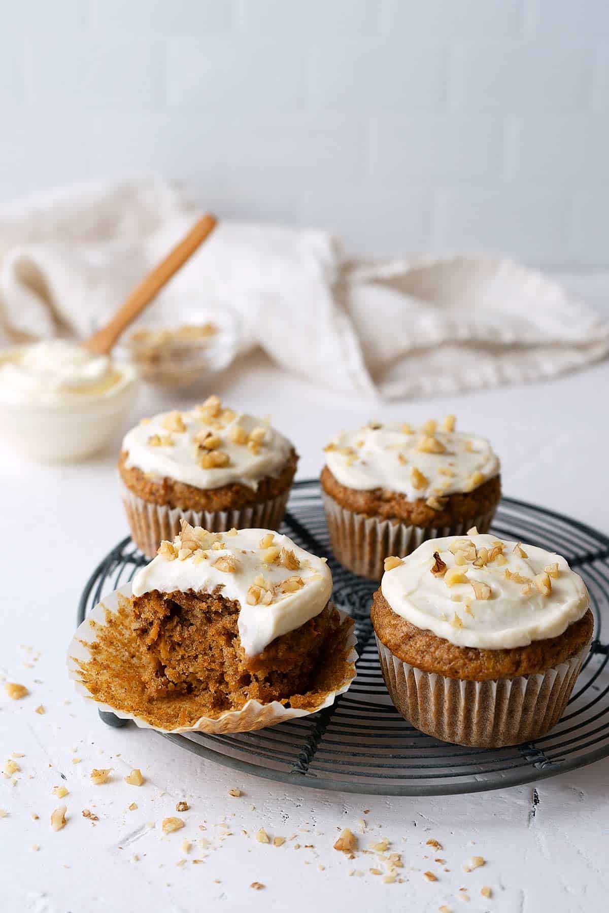 a partially eaten carrot muffin on a cooling rack