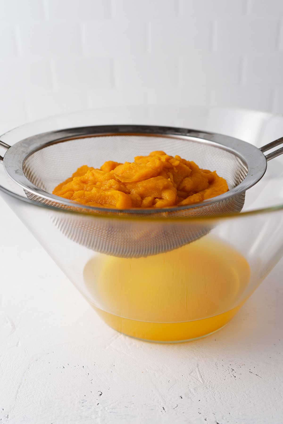 Draining pumpkin puree in a colander.