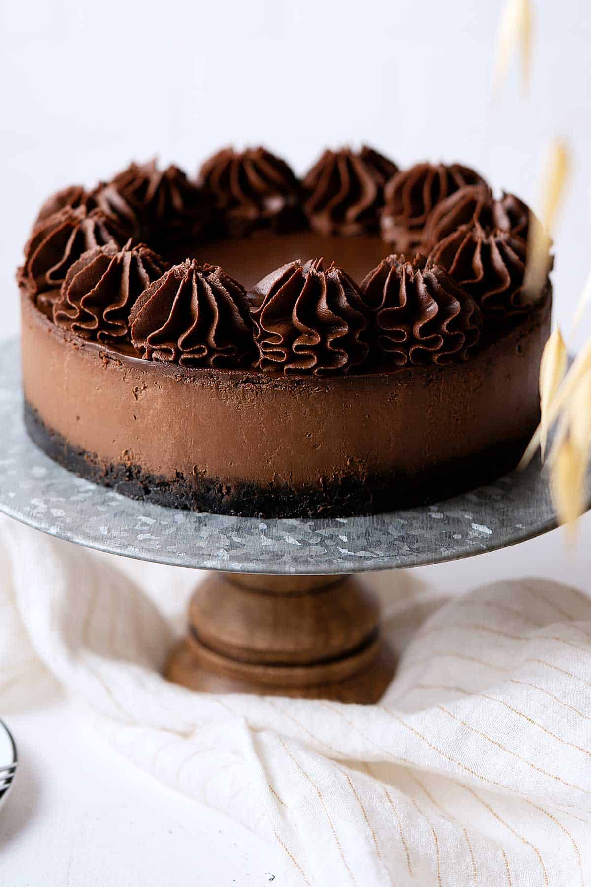 chocolate cheesecake on a cake stand.