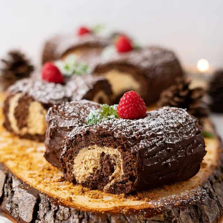 mini yule logs decorated on a wooden table.