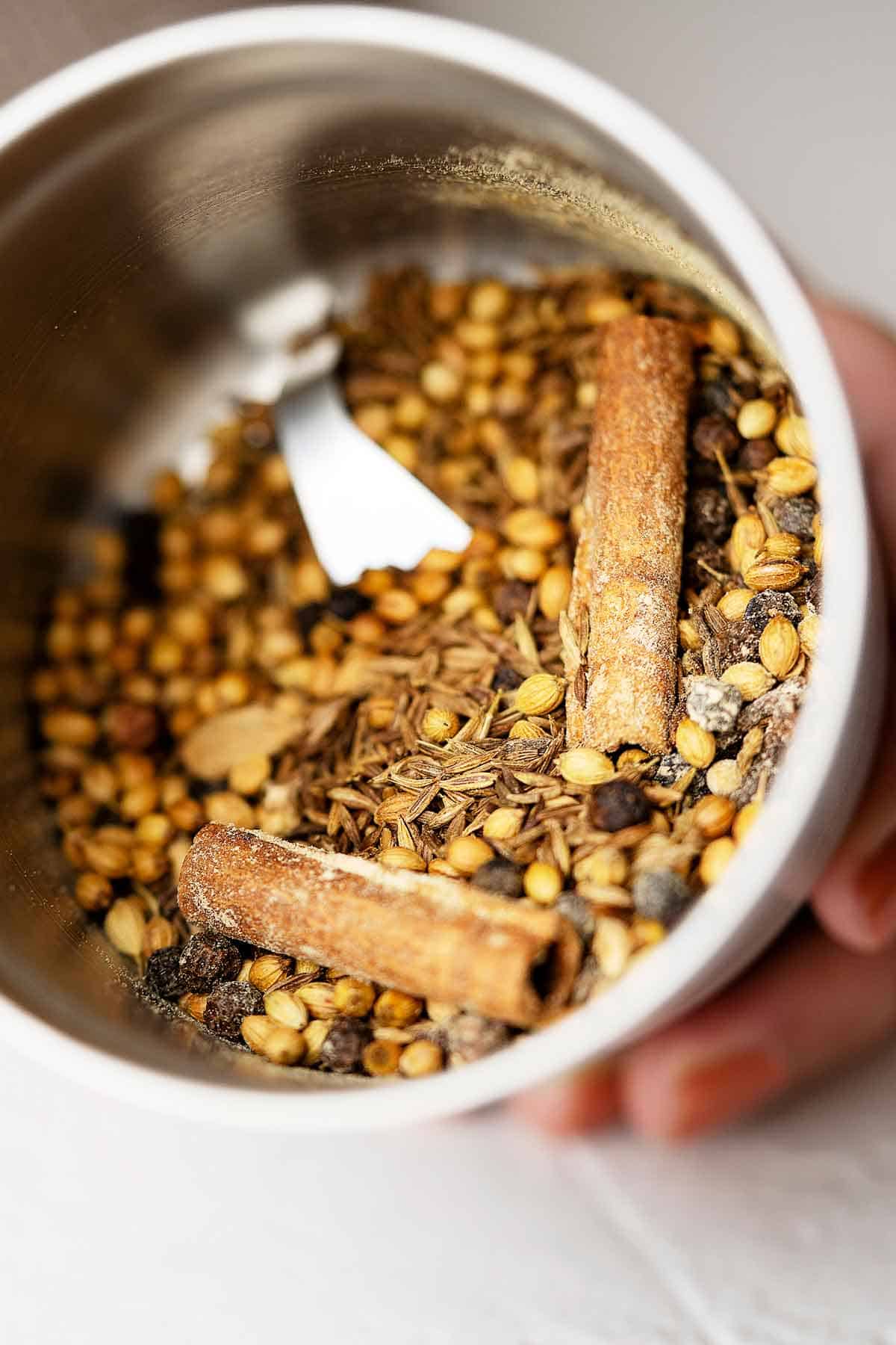 Spices for homemade garam masala in a grinder bowl