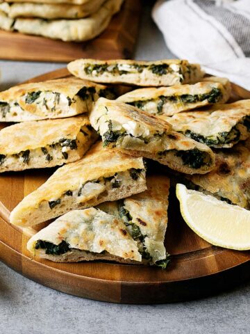 Slices of spinach and feta gozleme on a wooden plate