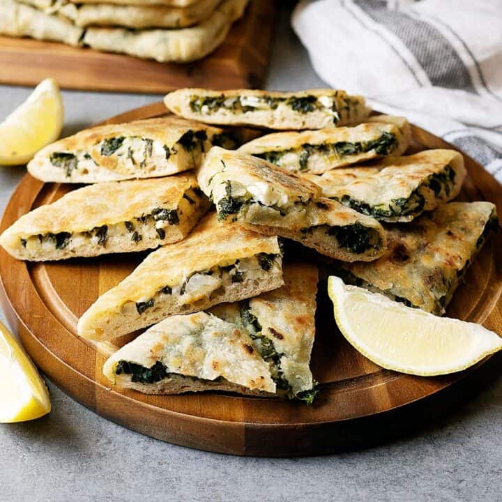 Slices of spinach and feta gozleme on a wooden plate
