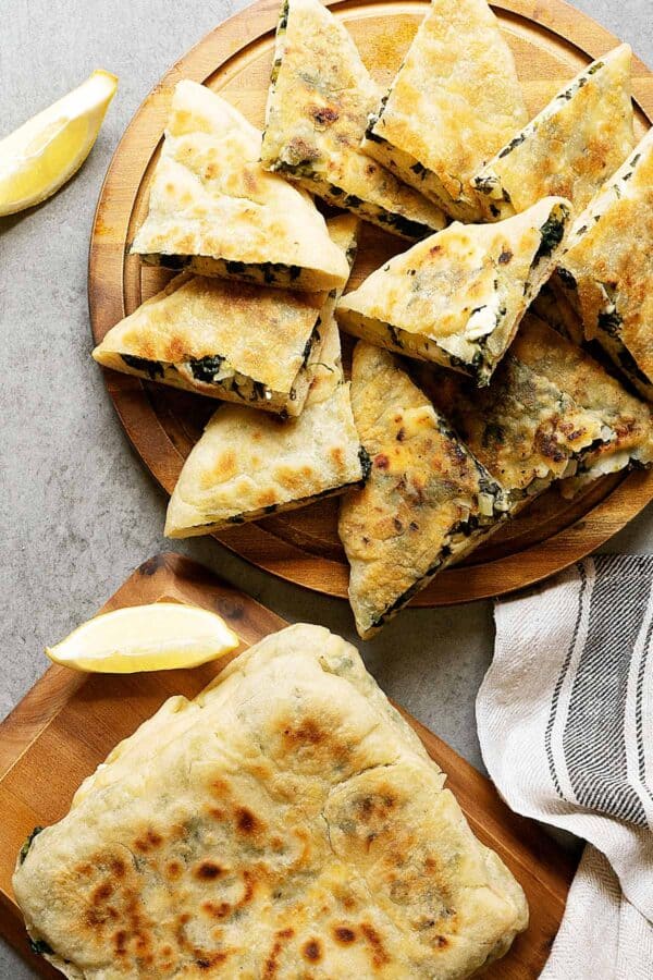 View from top of slices of spinach and feta gozleme on wooden plate