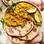 Holding a plate of lentils turmeric curry