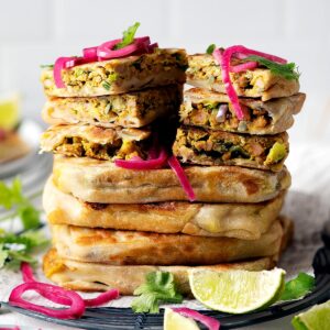 Whole and slices of chicken murtabak flatbreads stacked
