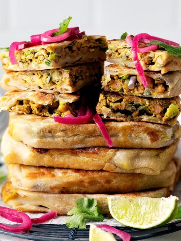 Whole and slices of chicken murtabak flatbreads stacked