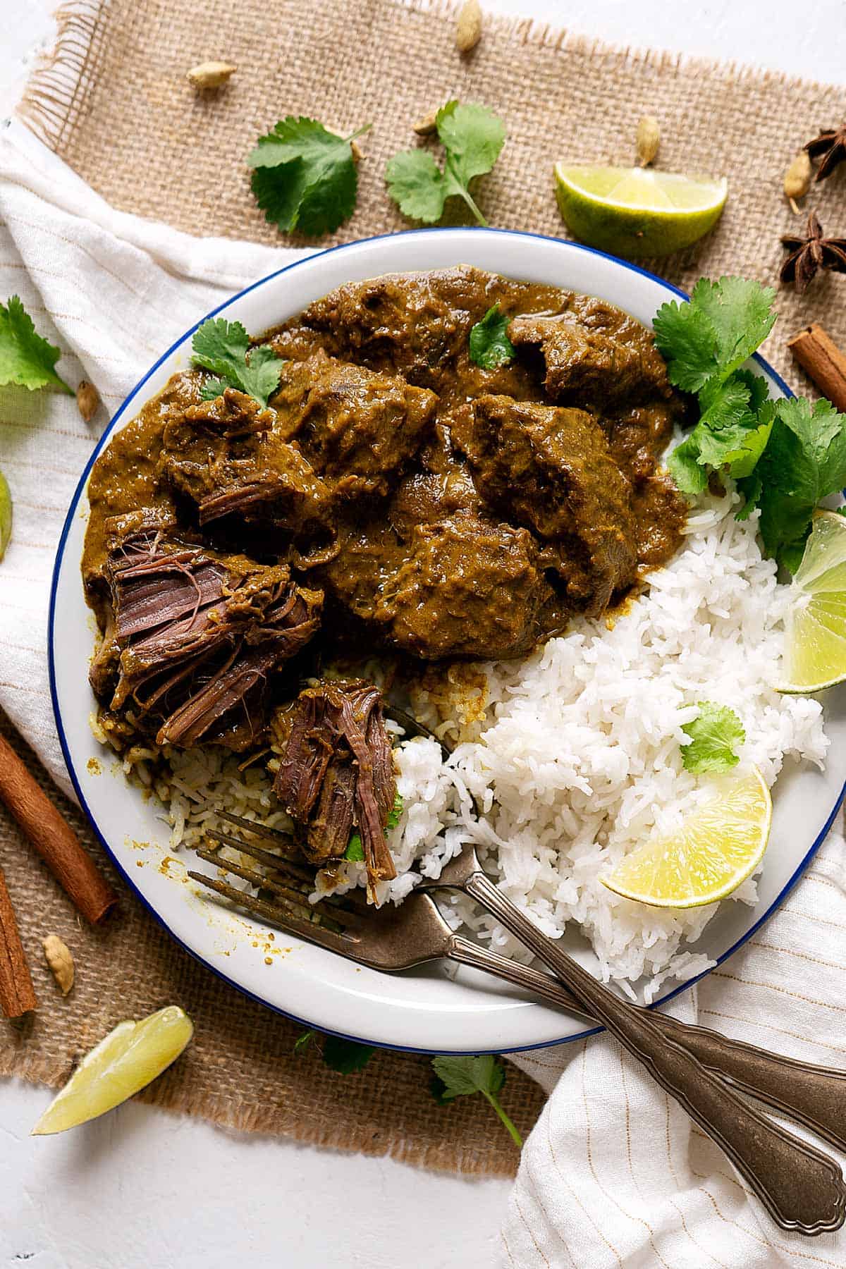 Half eaten slow cooker beef rendang in a plate with some rice