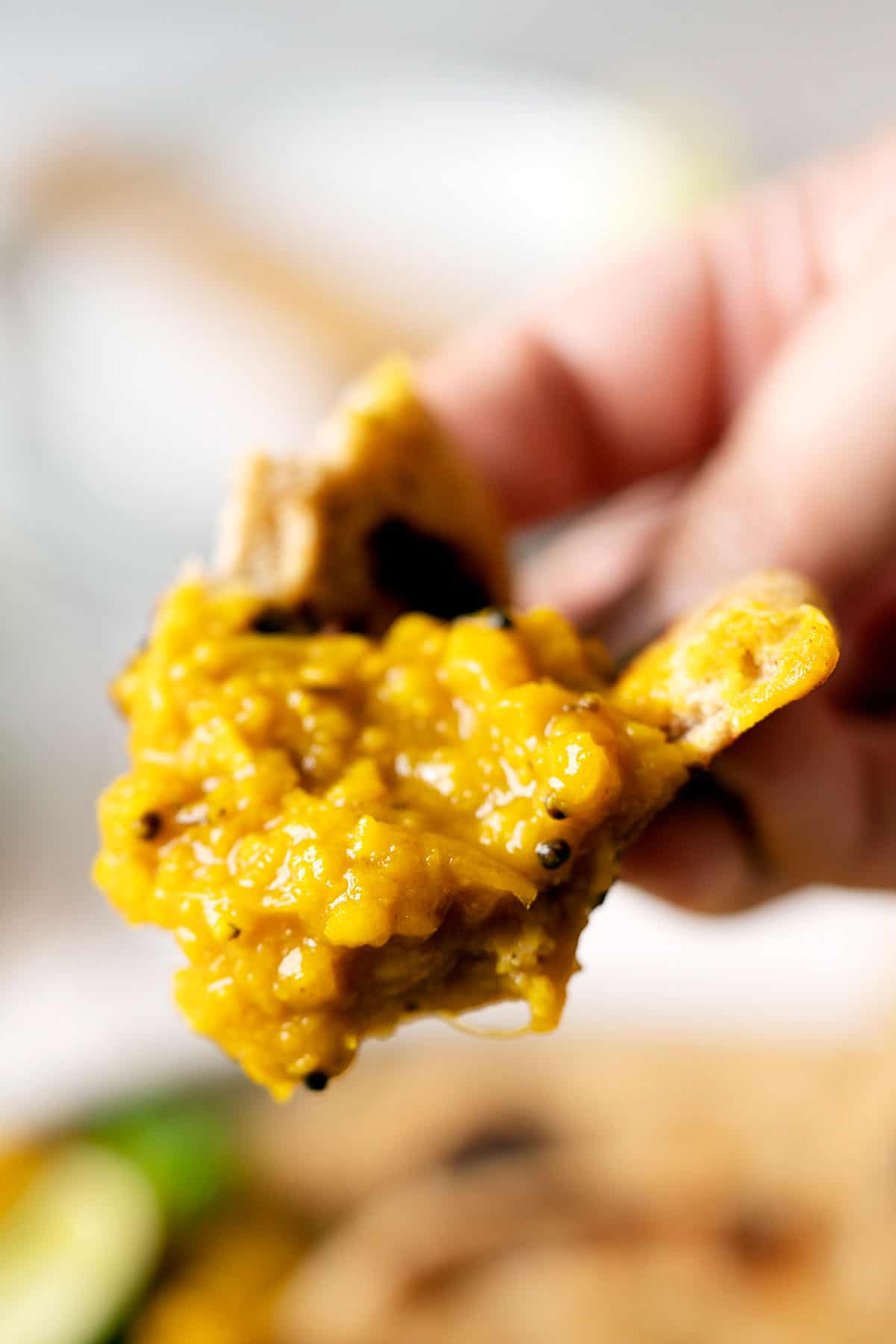 Holding a piece of flatbread dipper in lentils turmeric curry