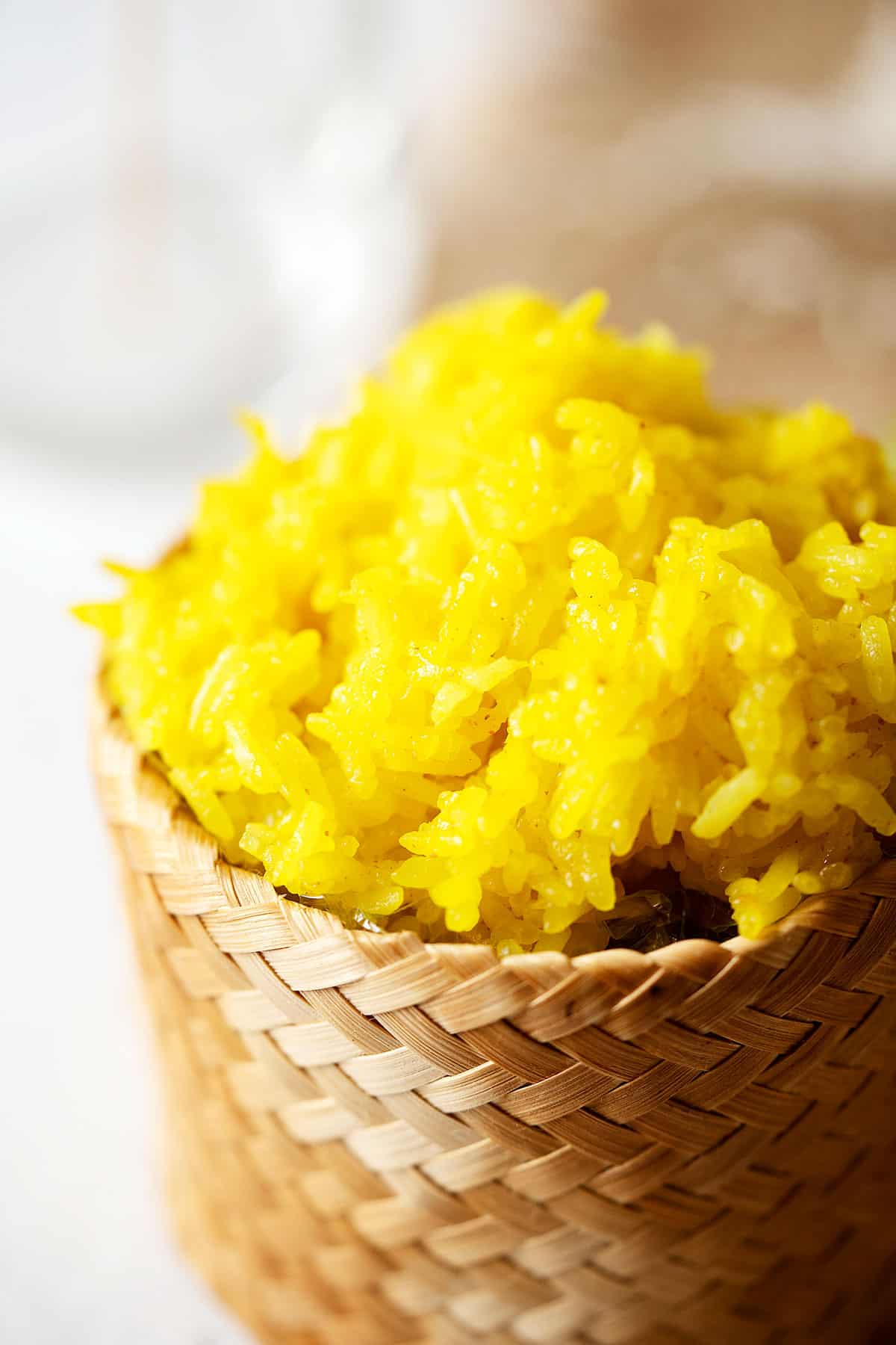 Steamed glutinous rice with turmeric and coconut milk in a bamboo basket