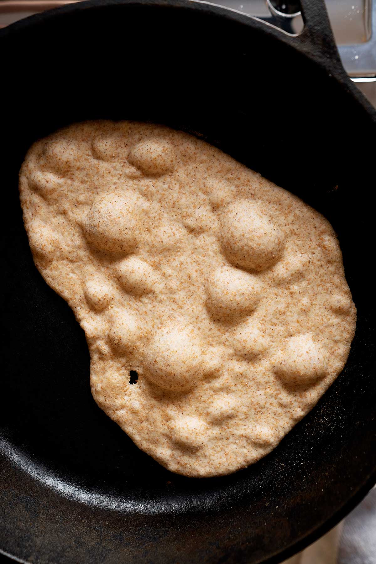 Cooking a whole wheat naan in a skillet