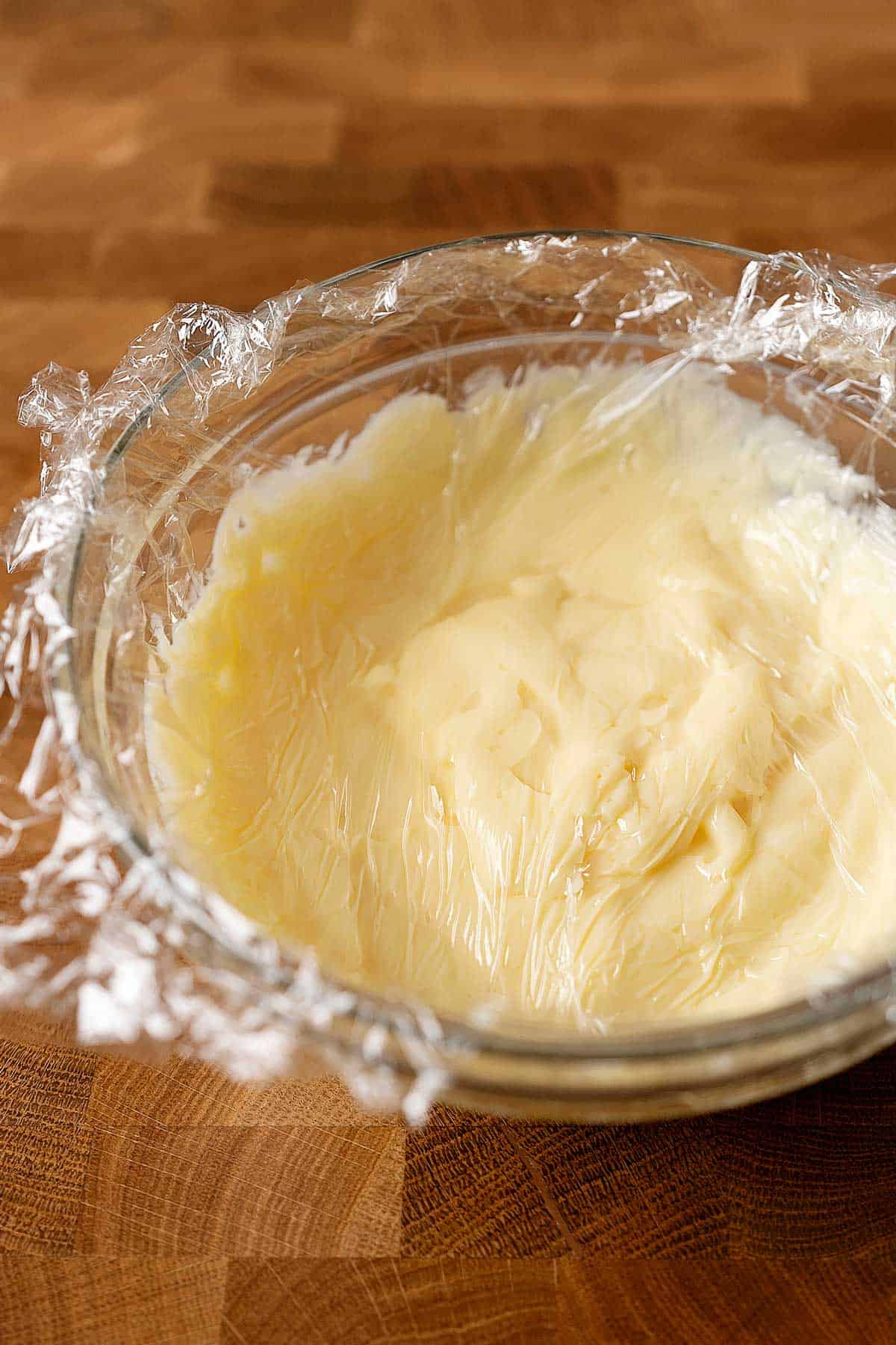 pastry cream in a bowl covered with cling film.