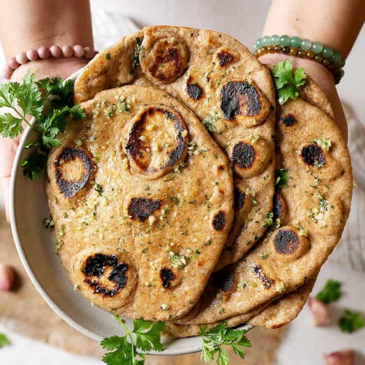 Holding a plate of whole wheat garlic naan
