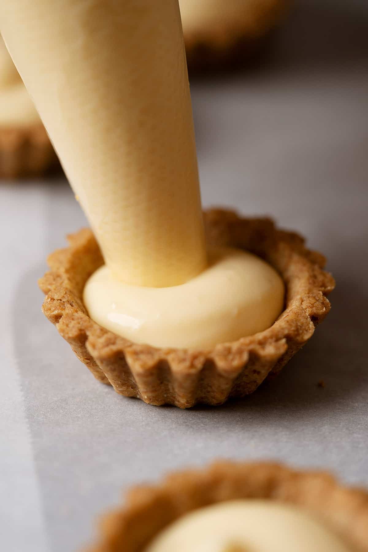 Piping pastry cream into spelt tart shell