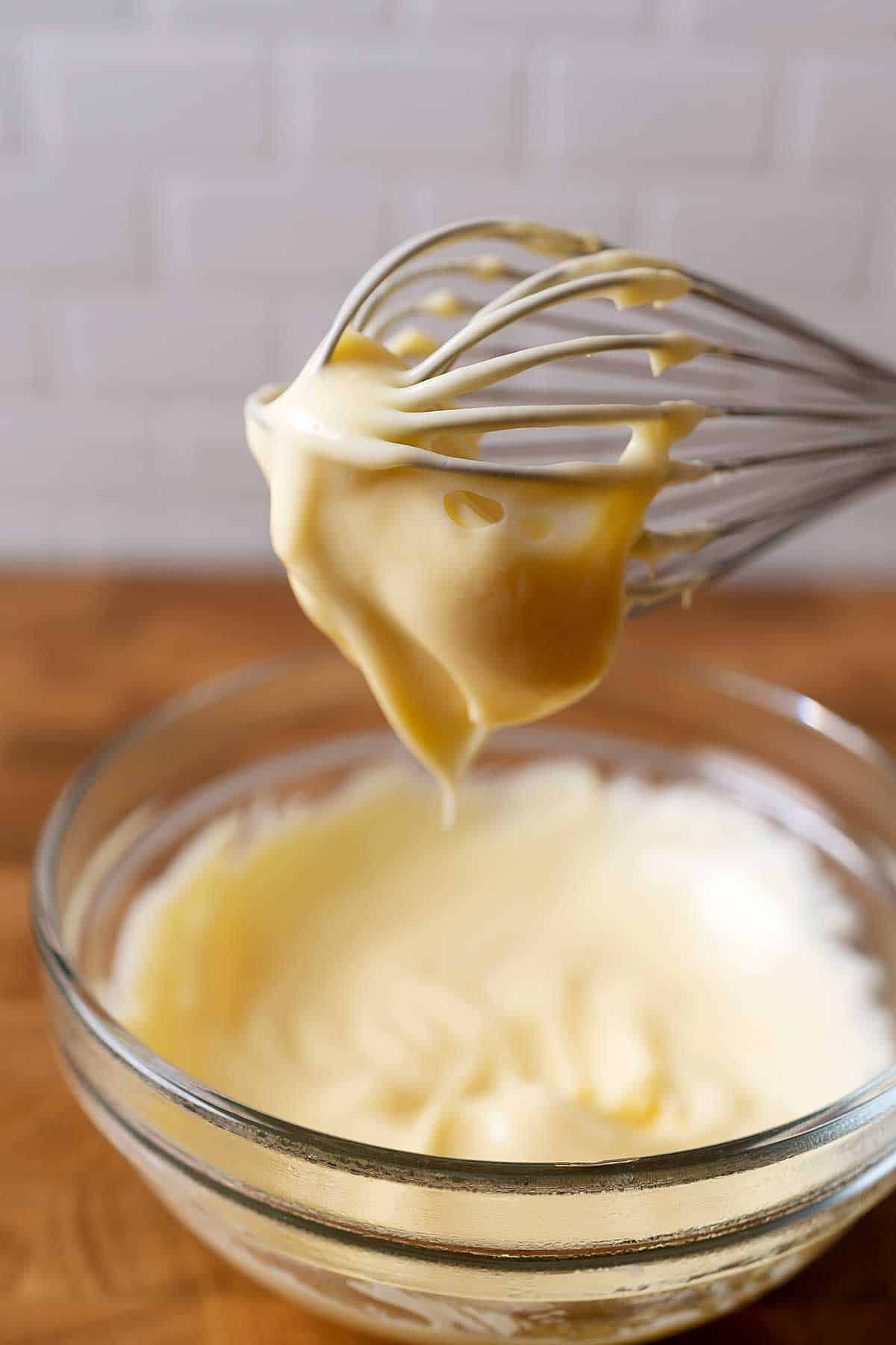 whisking pastry cream in a bowl.