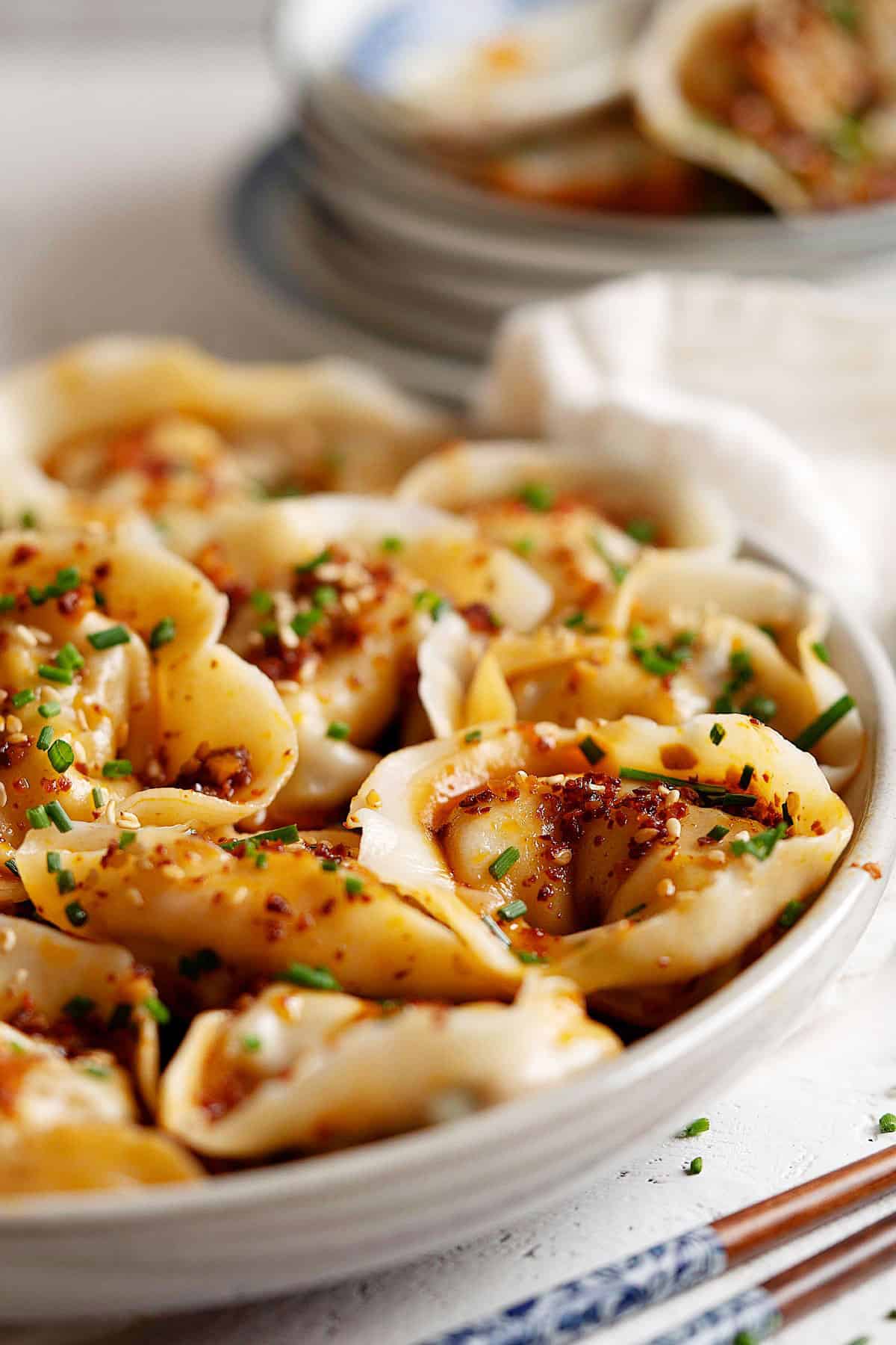 Close up of wontons in garlic chili oil in a plate