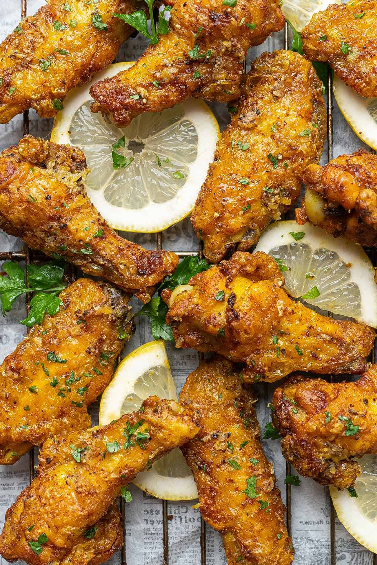 Close up of crispy baked lemon pepper chicken wings on a rack