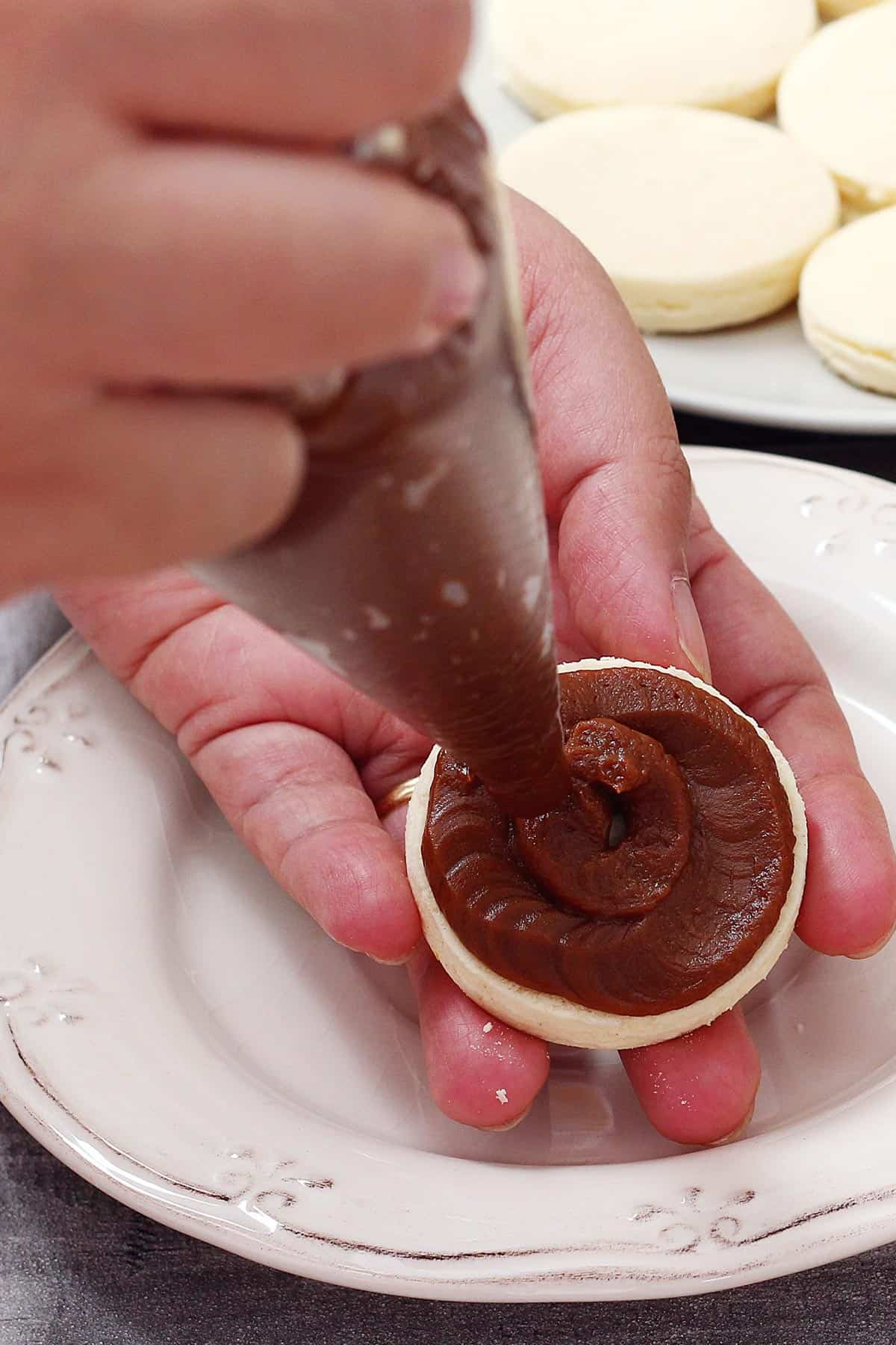 Piping dulce de leche to make Argentine alfajores