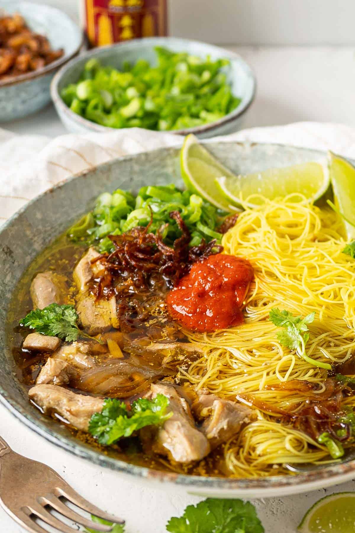 A bowl of lemongrass ginger chicken soup with turmeric rice noodle