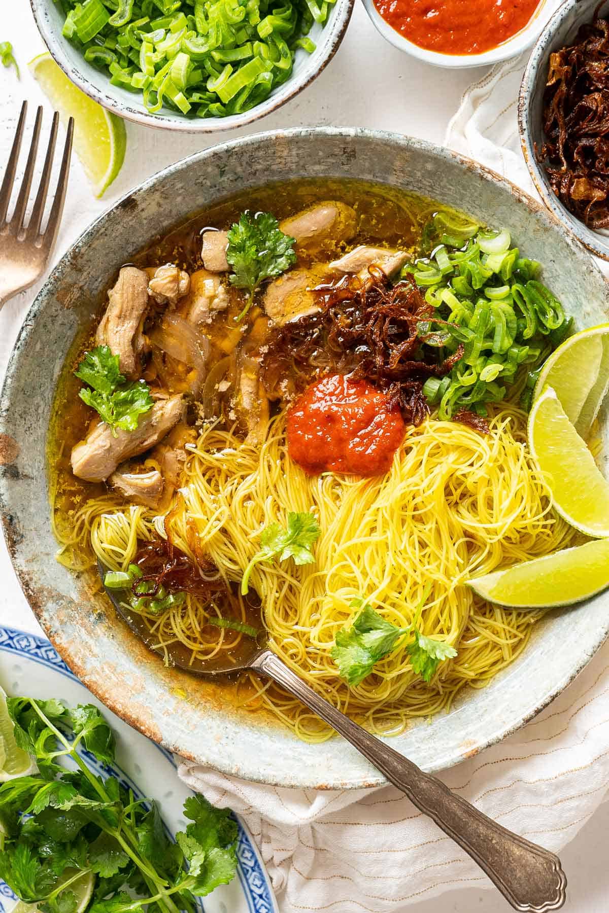 A bowl of lemongrass ginger chicken soup with turmeric rice noodles