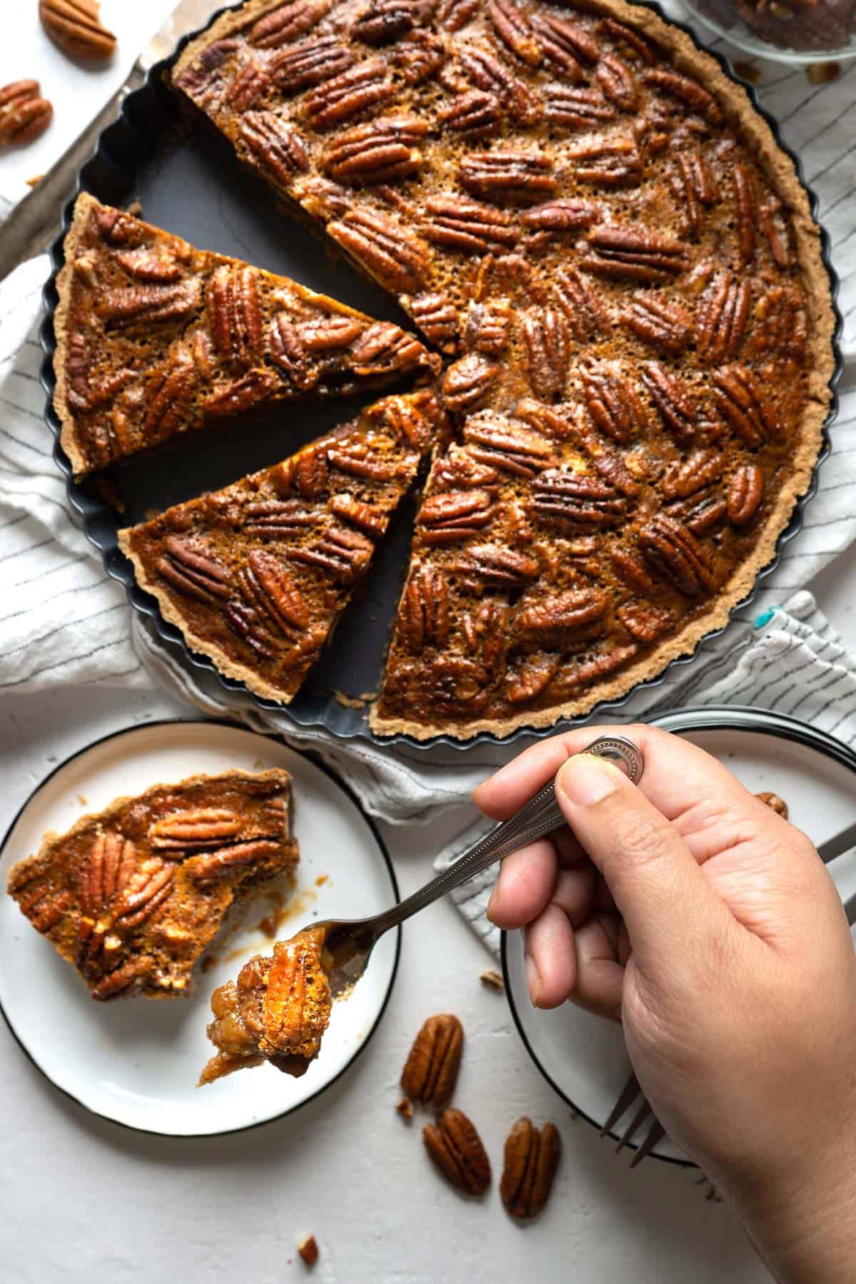 Spooning a bite of healthy pecan pie without corn syrup