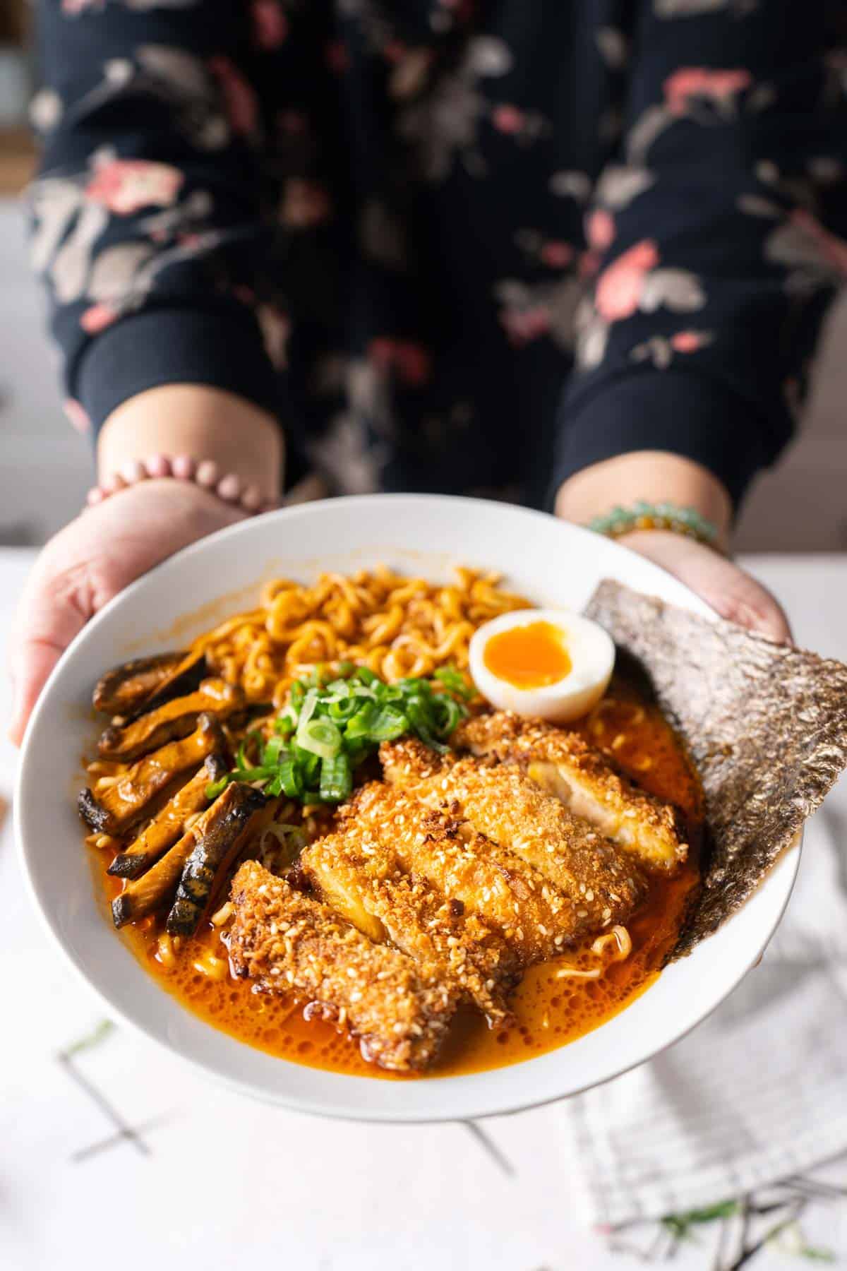 Serving a bowl of spicy ramen with chicken katsu