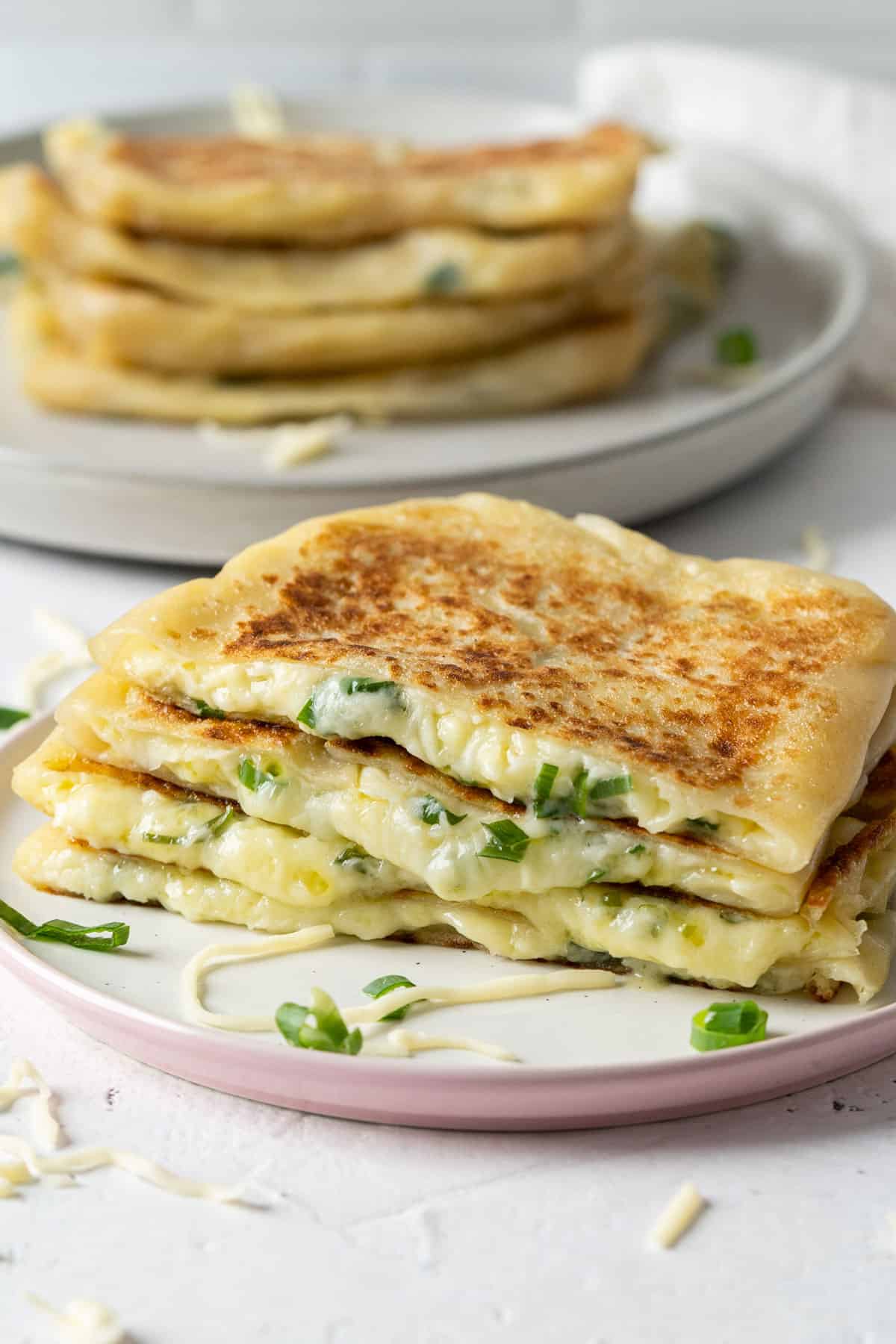 Cheese roti canai stacked up on a plate