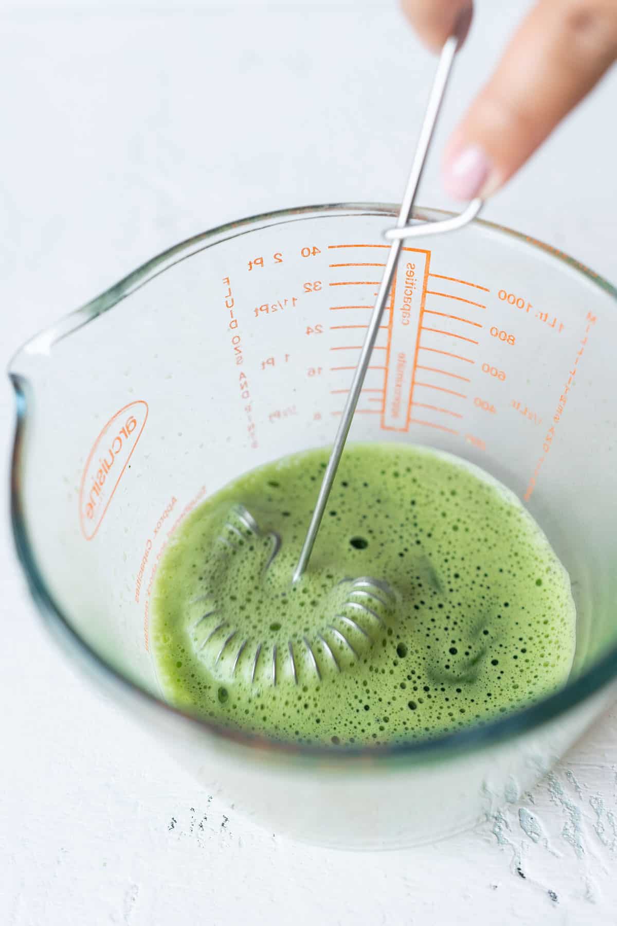 Dissolving matcha using a hand whisk.