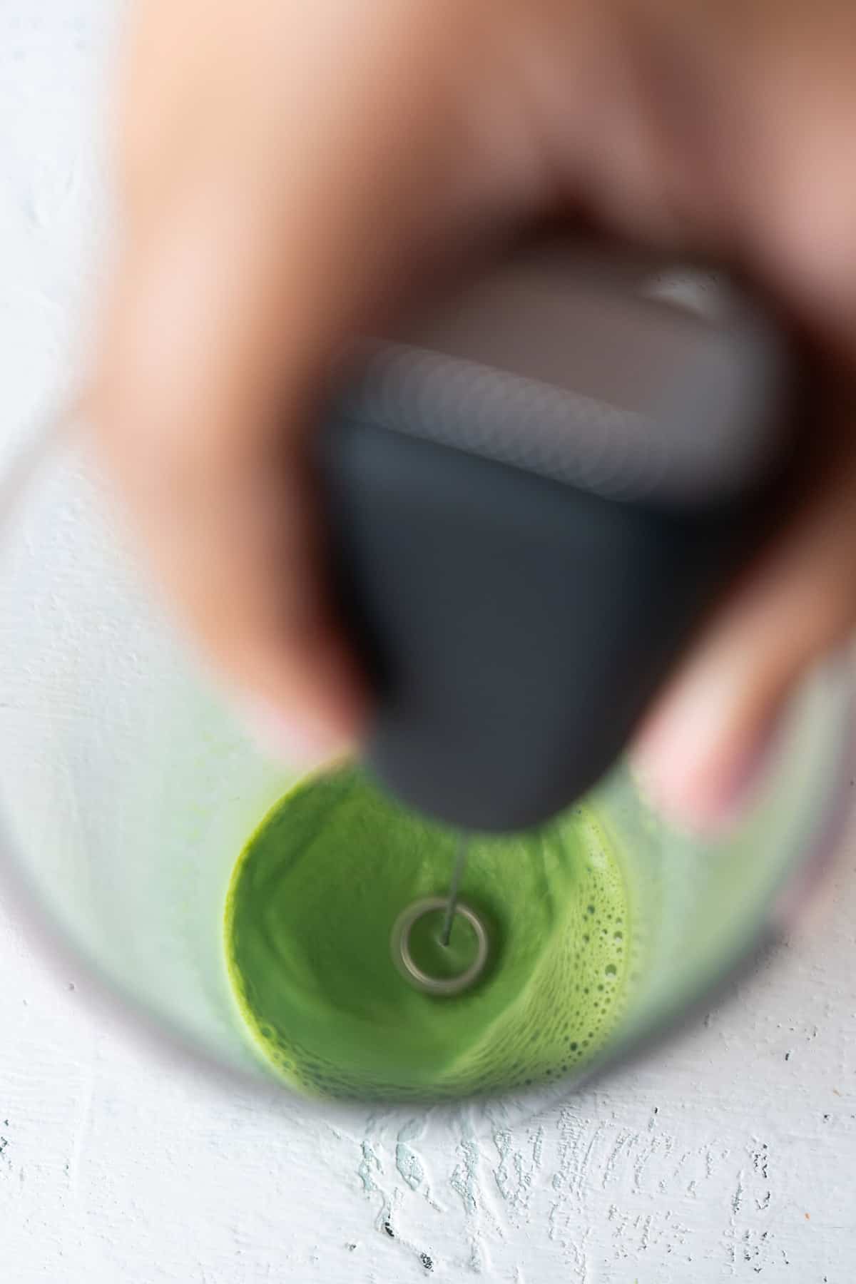 Dissolving matcha using a milk frother.