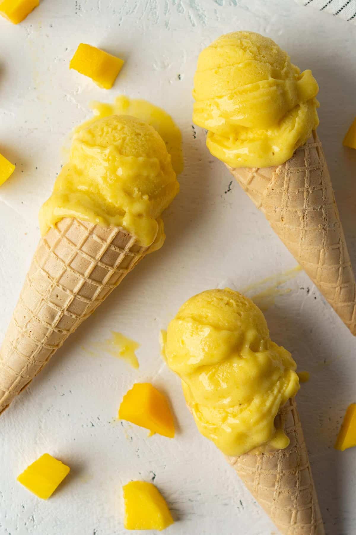 Healthy no-churn mango ice cream in ice cream cones.