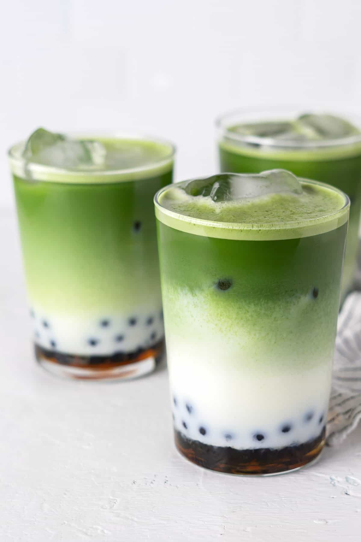 Matcha boba tea in 3 glasses.