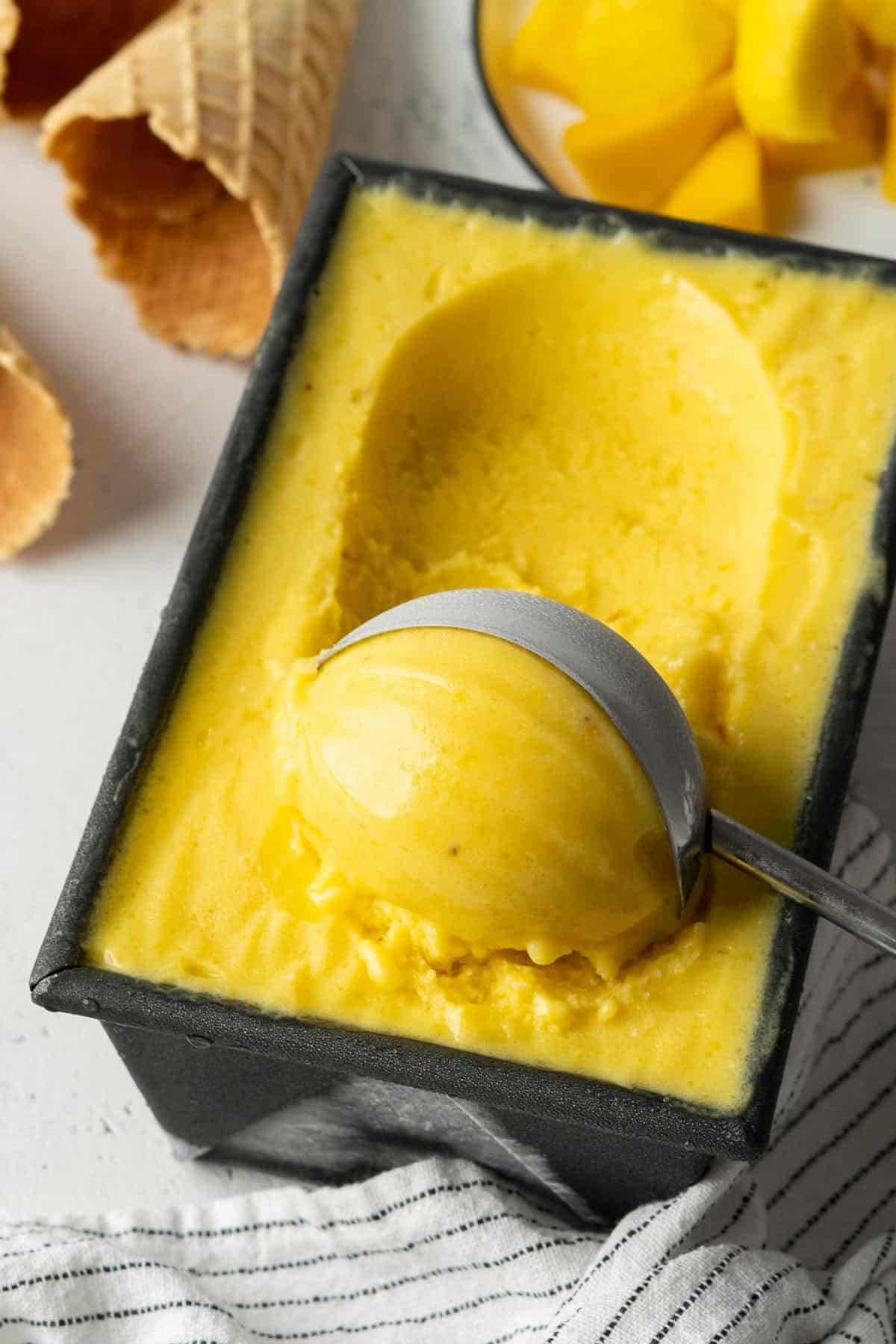Scooping healthy no-churn mango ice cream.