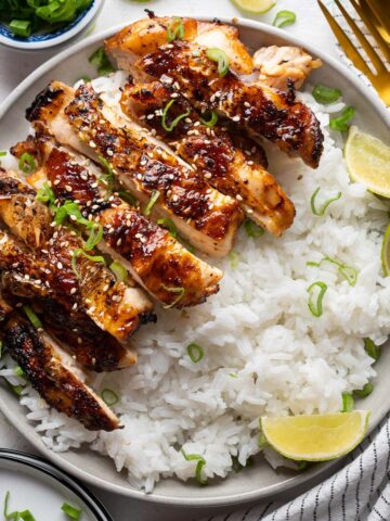 RC Sliced air-fryer soy sauce chicken with some rice in a plate view from top.