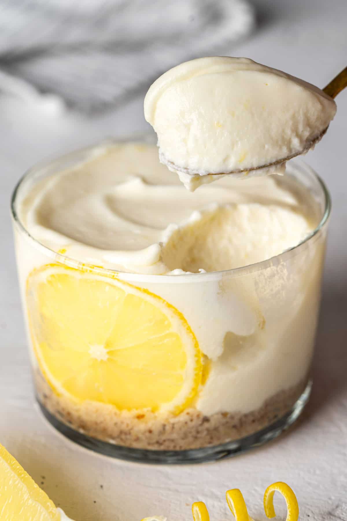 Spooning healthy no-bake lemon cheesecake cup.